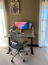 Last inn bildet i Galleri-visningsprogrammet, Pomelo kontorstol - grå stoff og lysegrå understell. En fremvisning fra showrommet der kontorstolen er satt sammen med en hev senk pult. 
